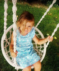 Child sitting in Kids Hammock Swing Chair For Indoor And Outdoor Fun, Handmade Macrame Knitted Hanging Seat For Toddlers Aged 2 To 5