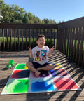 Child sitting on Liquid Sensory Floor Tiles 15.8 Inch Square 4 Pack Colorful Fun Non-Toxic Liquid Moves With Every Step Anti Slip Backing