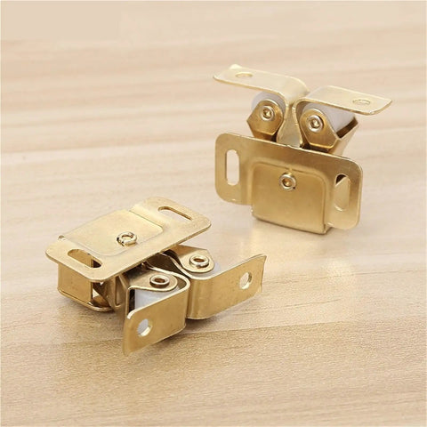 Brass magnet cabinet catches and door stopper closers with dampers and buffers on wooden surface