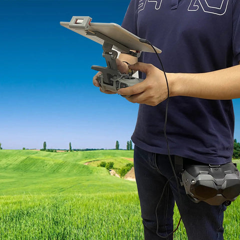 Person holding an FPV Remote Controller 2 Tablet Mount For DJI FPV Drone Fits 4.7 To 12.9 Inch Tablets in a field setting