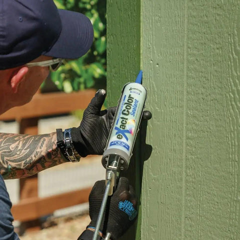 Person applying Exact Color Custom Colored Caulk DIY Kit with 9.5 Ounce Cartridge on green wood surface for seamless edges.
