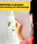 Legit Wall Safe Tape With Smooth Hold Go To Removable Rolls For Hanging Frames And Wall Decor Easy Peasy Peel And Stick Zero Damage Promise Two Mega Refills Inside, removing a calendar from the wall.