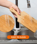 Bamboo cutting board, 11x5 in, 0.39 in thick, natural finish; being rinsed under running water.