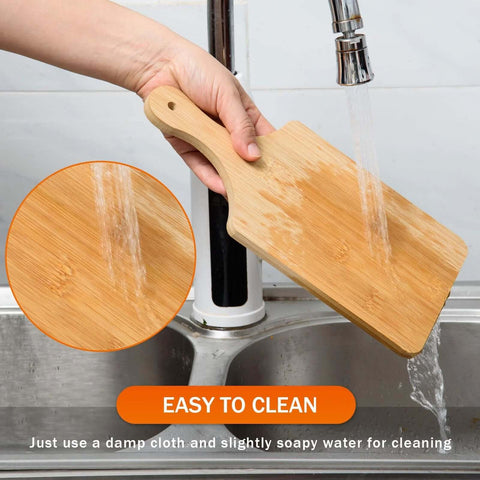 Bamboo cutting board, 11x5 in, 0.39 in thick, natural finish; being rinsed under running water.