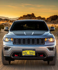 Front view of a car with Dope Carbon Fiber Look License Plate Frames 2 Pack Matte Black Aluminum Car Tag Holder against desert backdrop
