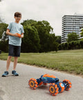 Child operating 4WD Gesture Control RC Stunt Car For Kids, Hand Sensing Remote Car With Lights And Music on outdoor path