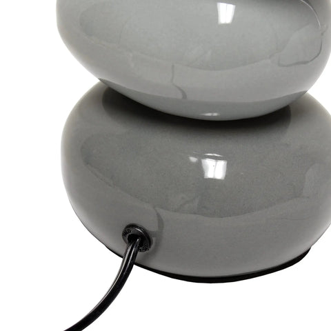 Close-up of Shades Of Gray Ceramic Stacked Stone Table Lamp With Fabric Shade, showing gray ceramic base with cord.