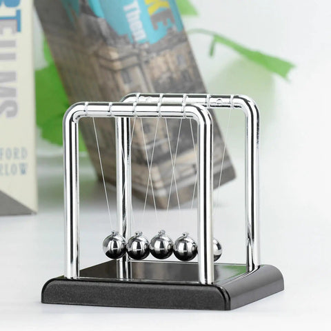 Five Ball Newton's Cradle Desktop Toy For Office And Home Decor With Black Wood Base And Strong Nylon String, Classic Science Gadget For Stress Relief And Desk Art displayed on desk.