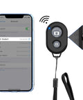 Two Pack Wireless Phone Camera Remote Shutter For iPhone And Android With Wrist Strap next to smartphone interface