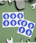 Ten Pack Protection Suit Warning Labels and Adhesive Safety Stickers for Factory Equipment with tools on green surface.