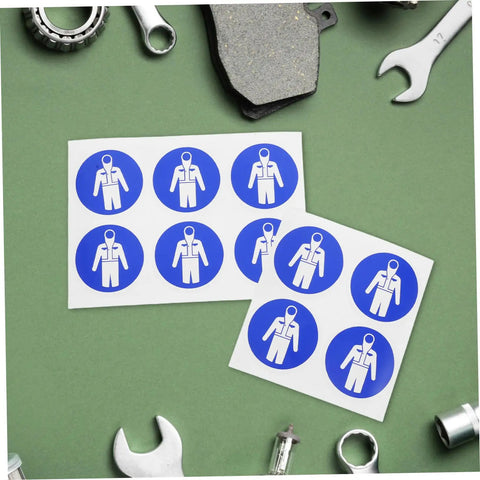 Ten Pack Protection Suit Warning Labels and Adhesive Safety Stickers for Factory Equipment with tools on green surface.