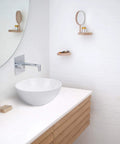 Compact 12 Inch Round Porcelain Vessel Sink With Pop Up Drain For Above Counter Vanity in modern white bathroom setting