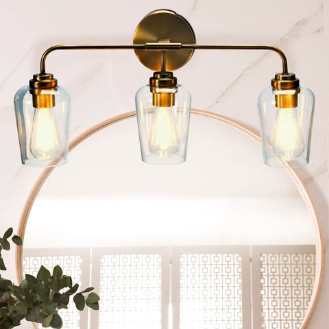 Mid Century Inspired Three Light Vanity Fixture in Brushed Bronze With Metal Base and Snifter Glass Shades above bathroom mirror