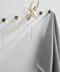 Straight Up Solid Wall Towel Hooks Set of Four Rustproof Stainless Steel Coat Hangers with gray towel and gold accents.