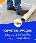 Person rolling out 36 Inch By 500 Foot Self Adhesive Carpet Protector Film For Construction on carpet, reverse-wound for easy use.