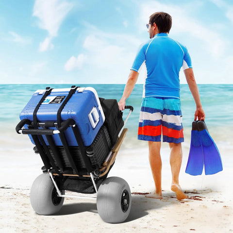 Man pulling beach cart with balloon wheels and large deck on sand, heavy duty load up to 165 pounds adjustable height foldable wagon
