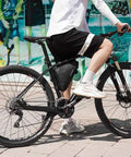 Cyclist riding bike with black On Frame Bike Triangle Bag With Dual Sided Pockets 1.5L Capacity Easy Access Tool Phone And Key Storage