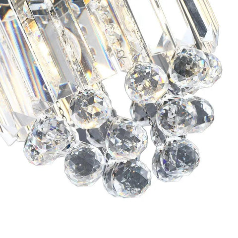 Close-up of crystal glass pendant light with beads, part of modern clear pendant fixture for kitchen island or dining room.