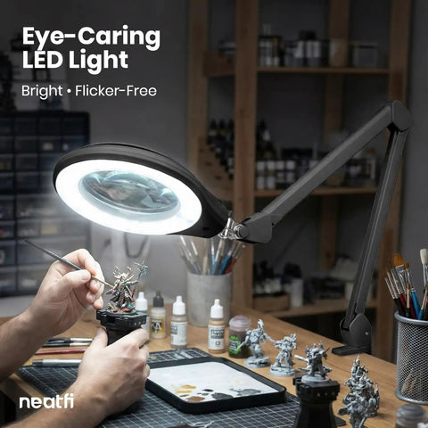 Pro Grade LED Magnifying Lamp With Clamp illuminating small figures on desk, 6 Inch Glass Lens, 5D And 12D Bifocal Magnification