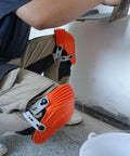 Person wearing Ultraflex Non-Skid Kneepads With Flexible Design, Orange Plastic Protective Gear for comfort during DIY tasks.