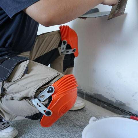 Person wearing Ultraflex Non-Skid Kneepads With Flexible Design, Orange Plastic Protective Gear for comfort during DIY tasks.