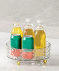 Non Slip Lazy Susan Turntable 9 Inch Clear One Tier Spinning Organizer For Kitchen Pantry Cabinet And Refrigerator, holding bottles and cans.