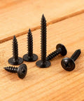 80 Piece Black Phillips Truss Head Self Tapping Screws One And One Half Inch Long arranged on a wooden surface