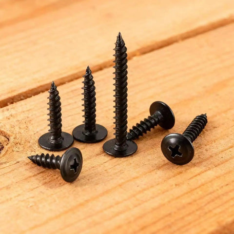 80 Piece Black Phillips Truss Head Self Tapping Screws One And One Half Inch Long arranged on a wooden surface