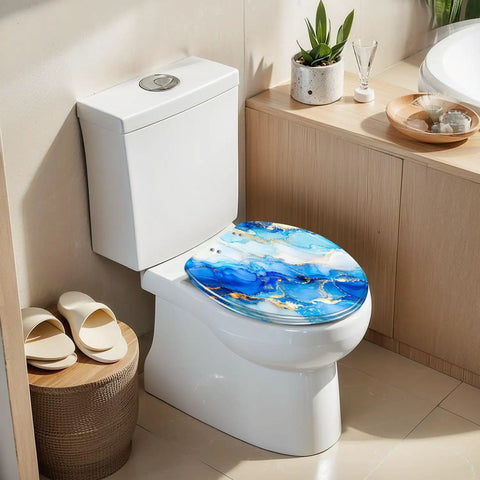 Elongated Alcohol Abstract Indigo White Gold Stains Stains Toilet Seat on a white toilet, showcasing blue and gold resin design.