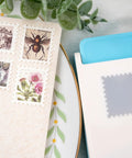 Lever Action Postage Stamp Punch 1x0.8 Inch Rectangular Stamp Shaped Paper Punch shown with cut stamps and craft paper.