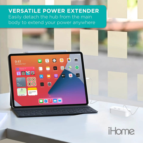 Tablet on a desk charging with Power Reach Pro Multi Outlet Extender with four outlets three USB ports and magnetic wall mount.