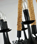 Rock Solid Industrial Chandelier Features Woven Hemp Rope And Sturdy Metal Candle Holders To Set A Chill Farmhouse Vibe while showcasing black metal holders and hemp rope.