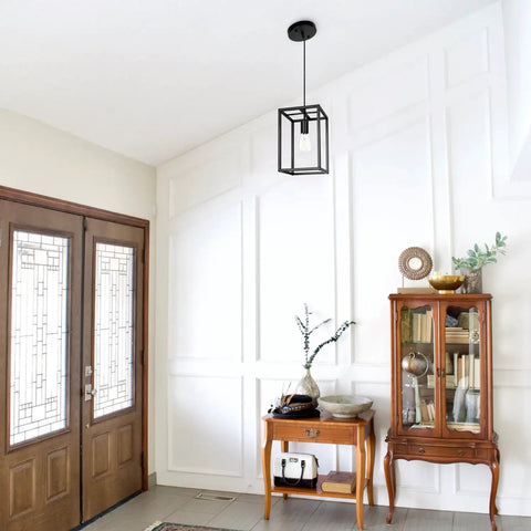 Industrial Black Pendant Light Fixture With Geometric Wire Cage hanging in modern entryway with wooden furniture