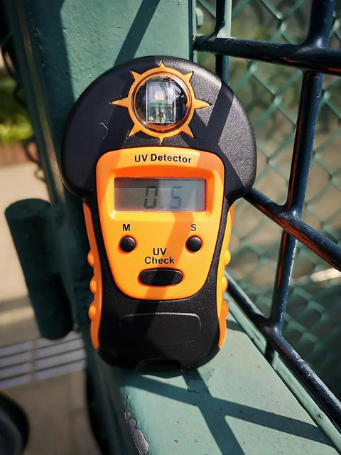 Portable Handheld Sun UV Detector For Measuring UV Levels Outdoors Easy To Use Sunlight UV Meter in orange, displaying 0.5 index