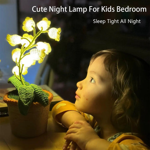 Child mesmerized by Crochet Lily of the Valley Lamp, Handmade Cordless Night Light with Touch Control, cozy bedside decor.