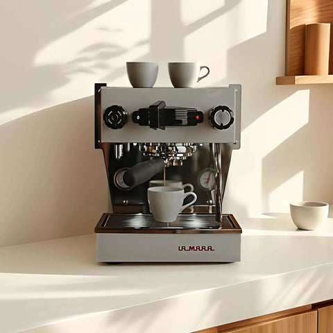 La Marzocco espresso machine brewing coffee, with two cups on top, in a bright kitchen setting.