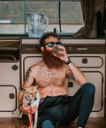 Man sitting in camper van with dog, drinking water, Pure Filter Water Pitcher For Refrigerator 10 Cup Capacity visible on counter.
