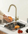 Sink Faucet,360°Pull-Out Spray,Brushed Steel Hot and Cold Rotation (Gold) with running water washing a pumpkin.