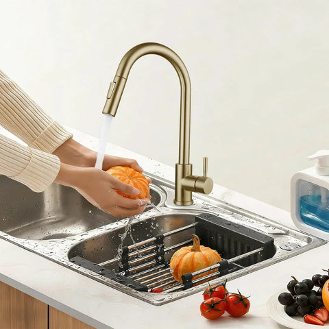 Sink Faucet,360°Pull-Out Spray,Brushed Steel Hot and Cold Rotation (Gold) with running water washing a pumpkin.