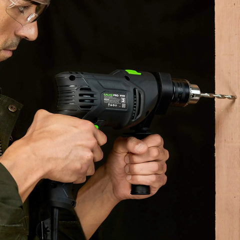 Person using Pro-Grade 5 Amp Half Inch Hammer Drill Kit With 105 Accessories, Variable Speed To 3000 RPM, on wood