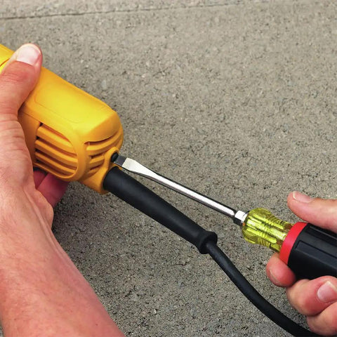 Hands adjusting cable on Powerful 9 Amp Four And A Half Inch Angle Grinder With Paddle Switch And 12,000 RPM Motor, ACDC Compatible.