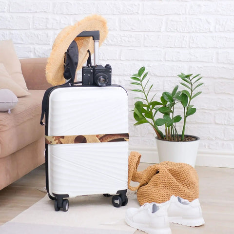 Cool Industrial Clock Gears Steampunk Print Luggage Strap on white suitcase with camera, hat, and plant beside it.