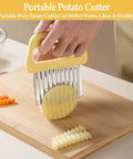 Front view of yellow handheld crinkle waffle fry potato cutter with multiple blades slicing a potato on a cutting board.
