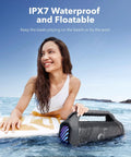 Boom 2 Plus Portable Speaker With 140W BassUp 2.0 held by a woman in a pool, demonstrating its IPX7 waterproof feature.