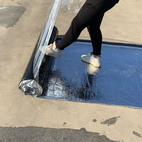 Heavy Duty Self Adhesive Roofing Tape Rock Solid Waterproof Asphalt Membrane Roll being installed with a foot push