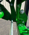 Detailed view of the No Hassle Dual Mount Tractor Pallet Forks connectors in bright green finish for front loader and hitch use.