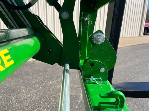 Detailed view of the No Hassle Dual Mount Tractor Pallet Forks connectors in bright green finish for front loader and hitch use.
