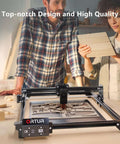 Front view of ORTUR Laser Master 2 S2 LU2-10A laser engraver on a workshop table with wood pieces