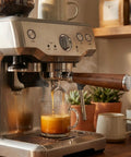 54mm Espresso Portafilter With Two Cup Spouts And Walnut Handle For Breville And Sage Barista Machines Fits Barista Express Pro Touch Bambino Series Stainless Steel Basket, brewing espresso in a kitchen setting