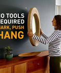 Woman using Heavy Duty Claw Drywall Picture Hanger 3 Pack For Heavy Mirrors And Artwork Steel Locking Claw Secures Into Drywall Spot Marker For Precise Hanging Points No Stud Finder Or Tools Required to hang mirror